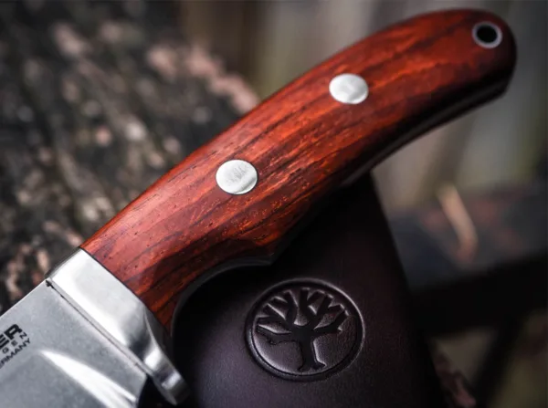 Nóż Böker Savannah Cocobolo Boker Savannah to profesjonalny nóż myśliwski i na zewnątrz ma imponującą ostrze i eleganckie linie. Konstrukcja Armin Stutz, od sztućców Styrii żelaza, został stworzony dzięki dużemu doświadczeniu w wielkich polowań w RPA, we współpracy z profesjonalnymi leśniczych. Masywna ostrze ma jasny stonewashed wykończenie i jest wykonany z kobaltem-N690. Ciągły pełnej wytrzymałości trzpień daje noża wyjątkową stabilność. Uchwyty wykonane są z certyfikowanego drewna przywiezione Cocobolo dać nóż tradycyjny wygląd. Załatać szczęki ze stali nierdzewnej i otwór smycz zakończyć wyrafinowany wystrój. Potężny i atrakcyjne wizualnie towarzysz dla wszystkich zajęć na świeżym powietrzu. Kołczan z powłoką skóry.