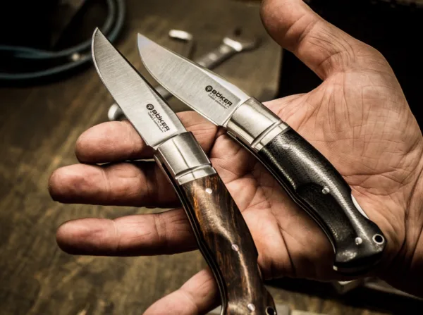 Nóż Böker Boxer Micarta Raphaël Durand aus Thiers ist als Custom-Messermacher inzwischen einer der gefragtesten in Frankreich. Seine handgearbeiteten Stücke erzielen international Höchstpreise, und sein Auftragsbuch ist mehr als voll. Umso mehr freuen wir uns, nach dem Slack von Böker Plus nun aus unserer Solinger Manufaktur eines seiner gefragtesten Modelle anbieten zu können, das Boxer. Der klassische Backlock vereint mediterrane Einflüsse bei der Klingenform mit denen eines traditionellen Taschenmessers und stellt so eine reizvolle Kombination dar, die eine einzigartige Ausstrahlung besitzt. Die Klinge wird aus N690 gefertigt und ist mit einem feinen Satin-Finish versehen. Die Edelstahlbacken tragen die für Raphaël Durand typische Nut. Die Beschalung besteht aus griffigem und stabilem Canvas-Micarta, das hier mit einem schönen gebürsteten Finish versehen ist. Die handliche Größe ist der perfekte Kompromiss zwischen Taschentauglichkeit und Vielseitigkeit im Einsatz, sodass das Boxer ein echter Allrounder ist, der die Freunde besonderer Taschenmesser ganz sicher begeistern wird.