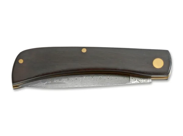 Nóż Magnum Ebony Rangebuster Damast Rangebuster to jeden z klasycznych noży Solingen, który zyskał międzynarodową popularność i został doceniony przez pracujących użytkowników na całym świecie. Amerykańscy rolnicy znają go jako Sodbuster, górnicy w północnej Francji nazywają go Mineur, a robotnicy w Solingen nazywają go Hippekniep. W hołdzie dla tego tradycyjnego noża ze złączem slipjoint zaprojektowaliśmy Ebony Rangebuster Damascus z ekskluzywną rękojeścią z ciemnego hebanu i ostrzem z 73-warstwowej stali damasceńskiej. Otwiera się przez nacięcie paznokcia i nie blokuje się.
