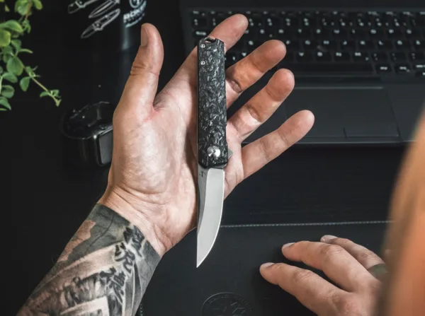 Nóż Böker Plus Kwaiken Compact Flipper Marble Carb Boker Plus Kwaiken Compact Lucasa Burnley'a, zaprojektowany jako tytanowa blokada ramy, jest krótszy i znacznie lżejszy niż wersja standardowa, ale nadal przekonuje z prawie niezmienioną siłą uchwytu. Skala przedniego uchwytu i przekładka ze zintegrowanym otworem na smycz są wykonane z dzikiego włókna węglowego, a tylna skala jest wykonana z tytanu i ma ukośną teksturę. Drobno wykończone satynowo ostrze z D2 otwiera się jak zwykle na łożyskach kulkowych przez flipper, a ogranicznik blokady działa jak ochrona zamka przed nadmiernym rozciągnięciem. Z głębokim klipsem do przenoszenia (tip-up / l-r) i wysokiej jakości nylonowym etui do przechowywania.