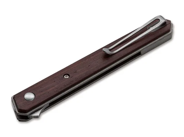 Nóż Böker Plus Kwaiken Air Cocobolo Brown Boker Plus Kwaiken Air Cocobolo od Lucasa Burnleya rozszerza dynastię odnoszącej sukcesy rodziny Kwaiken o elegancką lekką wersję. Dzięki prostemu i praktycznemu kształtowi ten nowoczesny scyzoryk stał się prawdziwą ikoną. Czyste linie i smukła konstrukcja tego modelu zostały dodatkowo zoptymalizowane, aby osiągnąć bezkompromisową redukcję wagi, chociaż nóż nadal trzyma całe ostrze, gdy jest zamknięty. Flipper zapewnia intuicyjną obsługę i dodatkowe bezpieczeństwo, a linerlock bezpiecznie blokuje ostrze łożyska kulkowego VG-10 z satynowym wykończeniem Hairline. Lekkość teczki Gentleman Folder podkreślają łuski na rękojeściach z delikatnego drewna cocobolo oraz zdejmowany, głęboki klips do przenoszenia (tip-up/r). Z otworem na smycz i wysokiej jakości nylonowym etui do przechowywania.