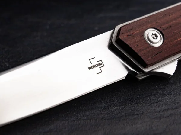 Nóż Böker Plus Kwaiken Air Cocobolo Brown Boker Plus Kwaiken Air Cocobolo od Lucasa Burnleya rozszerza dynastię odnoszącej sukcesy rodziny Kwaiken o elegancką lekką wersję. Dzięki prostemu i praktycznemu kształtowi ten nowoczesny scyzoryk stał się prawdziwą ikoną. Czyste linie i smukła konstrukcja tego modelu zostały dodatkowo zoptymalizowane, aby osiągnąć bezkompromisową redukcję wagi, chociaż nóż nadal trzyma całe ostrze, gdy jest zamknięty. Flipper zapewnia intuicyjną obsługę i dodatkowe bezpieczeństwo, a linerlock bezpiecznie blokuje ostrze łożyska kulkowego VG-10 z satynowym wykończeniem Hairline. Lekkość teczki Gentleman Folder podkreślają łuski na rękojeściach z delikatnego drewna cocobolo oraz zdejmowany, głęboki klips do przenoszenia (tip-up/r). Z otworem na smycz i wysokiej jakości nylonowym etui do przechowywania.