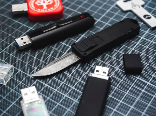 Nóż Böker Plus USA USB OTF Black Jako przenośny nośnik pamięci, pendrive'y stały się integralną częścią naszego codziennego życia. Boker i CobraTec, producent noży z USA specjalizujący się w pierwszorzędnych nożach OTF, tworzą synergię i przedstawiają Boker Plus USB OTF, który mocno przypomina charakterystyczny design zwykłych pendrive'ów USB. Nóż automatyczny posiada suwak z przodu rękojeści, który pozwala ostrzu D2 wystrzelić z rękojeści z szybkością strzały. Dzięki praktycznej obsłudze jedną ręką małe codzienne prace związane z cięciem są więc wykonywane w mgnieniu oka. Eleganckie, ciemne, stonewash wykończenie głowni doskonale współgra z prostą rękojeścią wykonaną z frezowanego CNC aluminium 6061-T6. Dzięki otworowi na smycz nóż można również idealnie nosić na breloczku do kluczy. Wyprodukowano we współpracy z firmą CobraTec, specjalistą Texas OTF.