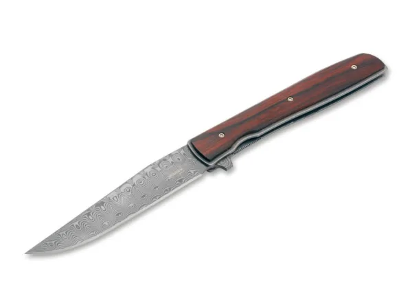 Nóż Böker Plus Urban Trapper Cocobolo Damascus Oryginalny model Boker Plus Urban Trapper autorstwa Brada Zinkera szybko stał się jednym z najpopularniejszych noży dżentelmeńskich w naszej ofercie i jest dostarczany z ostrzem wykonanym ze stali damasceńskiej nierdzewnej w szczególnie eleganckiej wersji kolekcjonerskiej. Niezwykle płaska i bardzo smukła konstrukcja sprawia, że Urban Trapper jest niezrównanym nożem składanym z wyższej półki. Głownia ze 110 warstw damastu zamocowana jest na łożyskach klulkowych, otwierana za pomocą flippera i bezpiecznie blokowana niezawodnym linerlockiem. Lekka rękojeść wykonana jest z tytanu z okładkami wykonanymi z klasycznego drewna cocobolo, które z jednej strony zapewniają nieco pełniejszy chwyt, a z drugiej - wyjątkowy wygląd. Przepiękna struktura czerwonawego drewna nawiązuje do marmuru, a dzięki wyjątkowo dużej zawartości olejków ma również intensywny kwiatowy zapach. Dostarczany z odpinanym klipsem do przenoszenia (tip-up/r) wykonanym z tytanu i wysokiej jakości nylonowym etui do przechowywania.