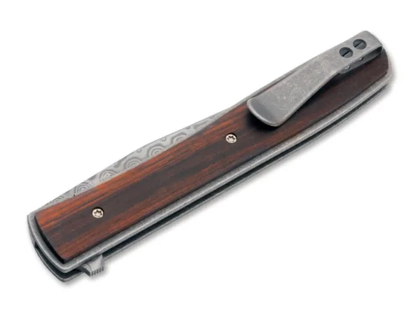 Nóż Böker Plus Urban Trapper Cocobolo Damascus Oryginalny model Boker Plus Urban Trapper autorstwa Brada Zinkera szybko stał się jednym z najpopularniejszych noży dżentelmeńskich w naszej ofercie i jest dostarczany z ostrzem wykonanym ze stali damasceńskiej nierdzewnej w szczególnie eleganckiej wersji kolekcjonerskiej. Niezwykle płaska i bardzo smukła konstrukcja sprawia, że Urban Trapper jest niezrównanym nożem składanym z wyższej półki. Głownia ze 110 warstw damastu zamocowana jest na łożyskach klulkowych, otwierana za pomocą flippera i bezpiecznie blokowana niezawodnym linerlockiem. Lekka rękojeść wykonana jest z tytanu z okładkami wykonanymi z klasycznego drewna cocobolo, które z jednej strony zapewniają nieco pełniejszy chwyt, a z drugiej - wyjątkowy wygląd. Przepiękna struktura czerwonawego drewna nawiązuje do marmuru, a dzięki wyjątkowo dużej zawartości olejków ma również intensywny kwiatowy zapach. Dostarczany z odpinanym klipsem do przenoszenia (tip-up/r) wykonanym z tytanu i wysokiej jakości nylonowym etui do przechowywania.