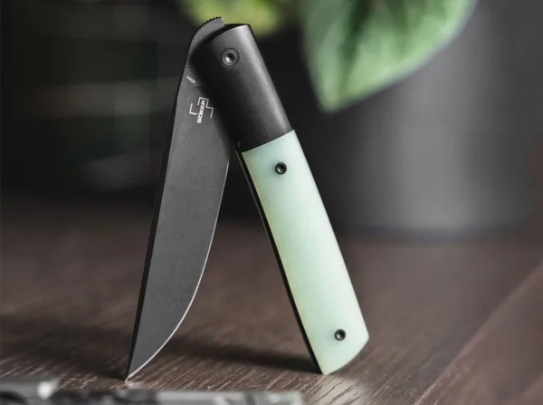 Nóż Böker Plus Urban Trapper Premium G10 Jade Boker Plus Urban Trapper zaprojektowany przez Brada Zinkera przekonuje w tej nowoczesnej wersji premium dostarczanej z ostrzem łożyska kulkowego wykonanym z metalurgii proszków M390 i dyskretnym przednim flipperem. Powlekana na czarno stal o wysokiej wydajności firmy Böhler wykazuje maksymalną odporność na zużycie i bez wysiłku radzi sobie ze wszystkimi codziennymi zadaniami cięcia. Ostrze jest unieruchomione solidną ramą z wkładką ze stali nierdzewnej. Wyżłobienia w okolicy oparcia kciuka dodatkowo zwiększają bezpieczeństwo pracy. Urban Trapper Premium ma integralną konstrukcję z wytrzymałym korpusem rękojeści wykonanym z czarnego powlekanego tytanu, który jest wyfrezowany z litego materiału i stanowi również wyprofilowane podpory dżentelmeńskiego noża. Powstałą lekkość stopy podkreślają podobnie wyprofilowane łuski uchwytów wykonane z Natural Jade G10, półprzezroczystej oryginalnej odmiany wytrzymałego materiału kompozytowego. Dostarczany z frezowanym klipsem z tytanu (czubkiem do góry/p) i wysokiej jakości nylonowym etui do przechowywania.