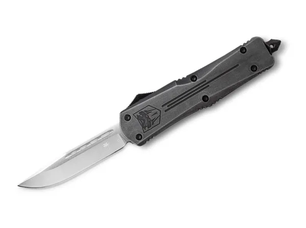 Nóż CobraTec Large Stonewash FS-3 Drop Dorosła wersja popularnego FS-3 przekonuje solidnym ostrzem typu drop point D2, które po naciśnięciu przycisku wysuwa się z przedniej rękojeści tak szybko jak strzała i znika tam ponownie po ponownym naciśnięciu. Nóż OTF (Out The Front) ma teksturowaną rękojeść wykonaną z aluminium o wysokiej wytrzymałości, która ma rustykalne wykończenie stonewash. Klips do przenoszenia głębokiego jest przymocowany do zbijaka do szyb i umożliwia przenoszenie po obu stronach. Dostarczany z wysokiej jakości nylonowym pokrowcem.