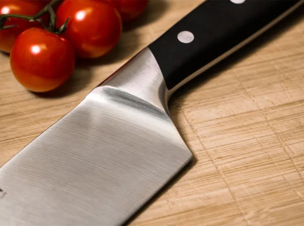 Nóż Santoku Böker Forge 16 cm Santoku to nóż, który staje się coraz bardziej popularny w Europie. Jest to japoński kształt ostrza noża uniwersalnego. Jego nazwa w tłumaczeniu oznacza "Trzy Cnoty". Z powodzeniem stosuje się go do mięs, ryb i warzyw. Szerokie ostrze sprawia, że ​​Santoku jest bardzo łatwy w obsłudze. Długość całkowita 293 mm, długość klingi 160 mm, grubość klingi 2.5 mm, waga 262 g.Seria Böker Forge to przystępna cenowo rodzina noży kuchennych, o klasycznych rysach i sprawdzonej technice. Kute z nierdzewnej stali chromowo - molibdenowo - wanadowej X50CrMoV15, są mocne, elastyczne i odporne na trudy codziennej pracy. Kształty ułatwiające ostrzenie i czyszczenie nie pozostają niezauważone przez użytkowników. Wygodna rękojeść z okładkami z tworzywa jest tak ukształtowana, by chronić rękę użytkownika przed zmęczeniem i skaleczeniem. Idealna seria dla tych, którzy potrzebują jakości w przystępnej cenie. Dostarczane w wysokiej jakości opakowaniu prezentowym.