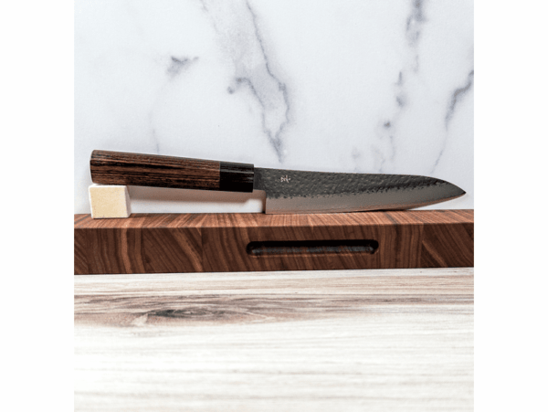 Shizu Hamono GEN Japoński nóż Gyuto 18cm VG-10 Shizu Hamono szczyci się wytwarzaniem noży, które bezbłędnie łączą estetykę z niezwykłą funkcjonalnością, wybitny podmiot w dziedzinie tradycyjnej ręcznie wykonanej sztuki wytwarzania z wykorzystaniem uświęconej tradycją techniki i stosowania najwyższej jakości materiałów Dane techniczne: Rękojeść: D Shape Pakkawood Stal: Damast VG10 Twardość / HRC: 60/62 Waga: 142 g Długość ostrza: 183 mm Długość całkowita: 323 mm Grubość grzbietu u podstawy: 2,2 mm Wysokość ostrza: 38,6 mm Wyprodukowano w Japonii Gyuto - nóż, który idealnie nadaje się do krojenia mięsa, drobiu, siekania warzyw i owoców, a także delikatnego filetowania ryb. Dzięki niemu unikniesz problemu odrapanych kawałków, które mogą zniszczyć Twoje kulinarne arcydzieła. Shizu Hamono wyróżnia się japońską stalą najwyższej jakości oraz wygodnym uchwytem, który zapewnia komfort podczas pracy. Gwarantujemy, że po doświadczeniu pracy z tym nożem, już nigdy nie będziesz chciał wrócić do innych narzędzi kuchennych. Wybierz Gyuto i poczuj różnicę, jaką może zrobić doskonały nóż w Twojej kuchni.